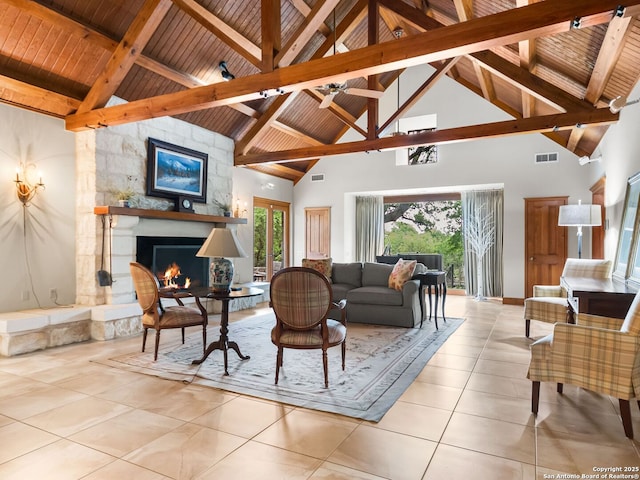 living room featuring visible vents, beam ceiling, a stone fireplace, high vaulted ceiling, and wooden ceiling