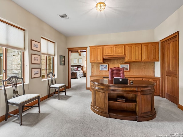 office with visible vents, baseboards, and light colored carpet