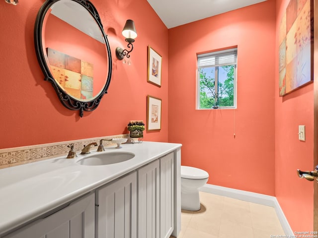 half bathroom featuring vanity, baseboards, and toilet