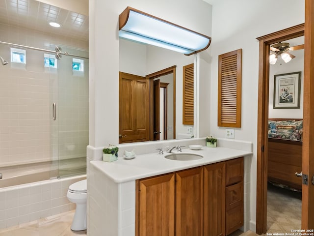 bathroom with vanity, ceiling fan, bath / shower combo with glass door, and toilet