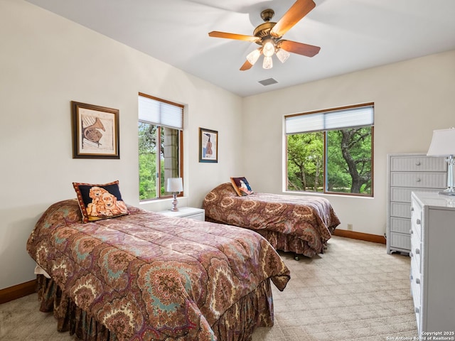 bedroom with baseboards, visible vents, multiple windows, and light carpet