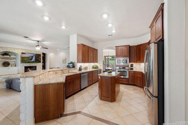 30406 Saddleridge, Bulverde, TX 78163 - kitchen featuring ceiling fan, a sink, arched walkways, stainless steel appliances, and a peninsula