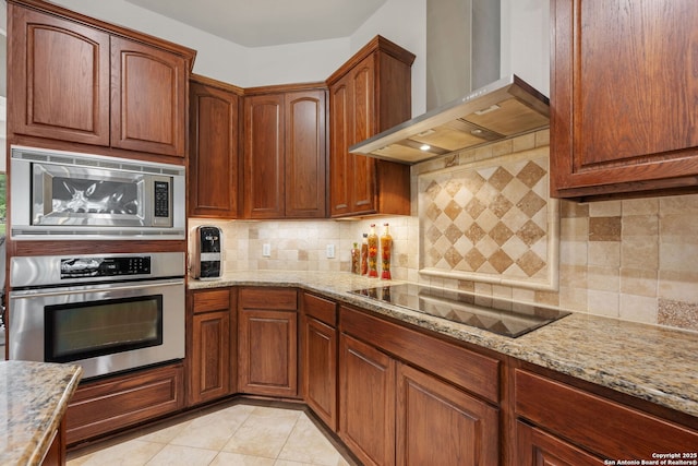 30406 Saddleridge, Bulverde, TX 78163 - kitchen with light stone countertops, appliances with stainless steel finishes, wall chimney exhaust hood, decorative backsplash, and light tile patterned floors
