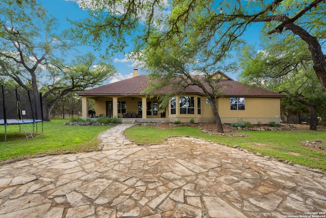 30406 Saddleridge, Bulverde, TX 78163 - rear view of house with a yard, a chimney, a trampoline, and stucco siding
