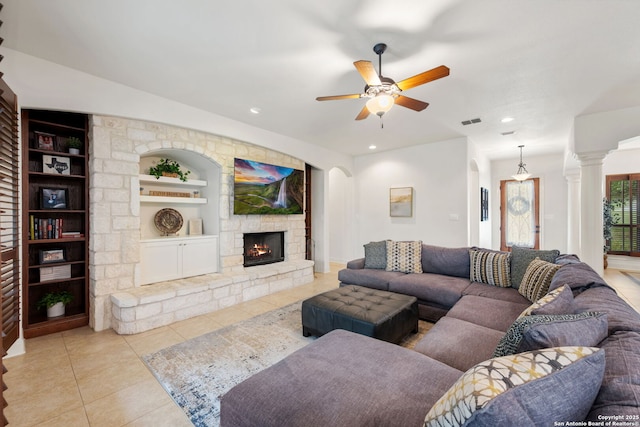 30406 Saddleridge, Bulverde, TX 78163 - living room featuring a ceiling fan, arched walkways, a fireplace, built in shelves, and light tile patterned floors