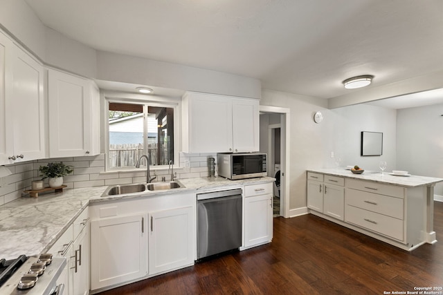 kitchen featuring a sink, dark wood-style flooring, backsplash, and stainless steel appliances