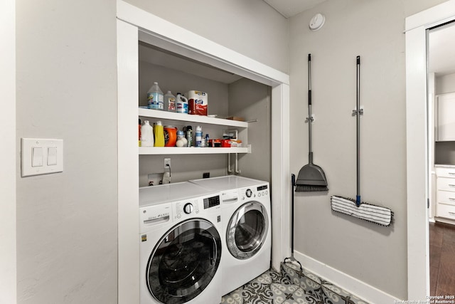 clothes washing area featuring baseboards, laundry area, and washer and clothes dryer