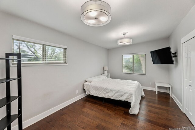 bedroom with baseboards, wood finished floors, and a closet