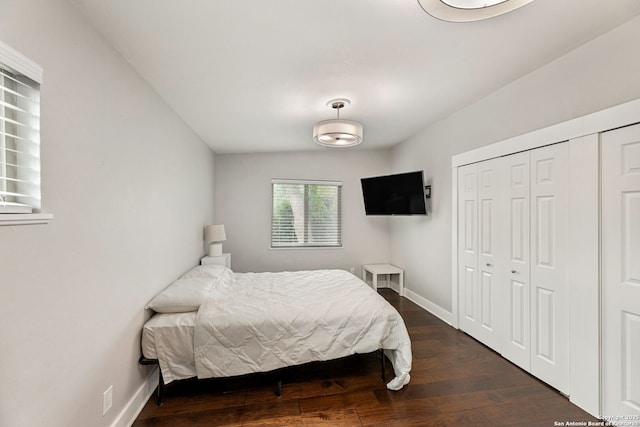 bedroom featuring baseboards, a closet, and dark wood-style floors