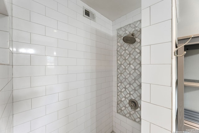 full bath with visible vents and tiled shower