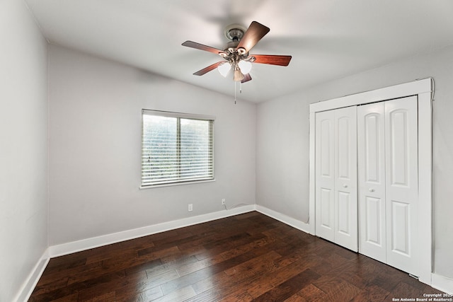 unfurnished bedroom featuring baseboards, ceiling fan, a closet, and dark wood-style floors