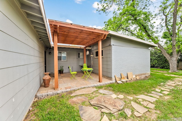 rear view of property featuring brick siding, a patio area, and a pergola