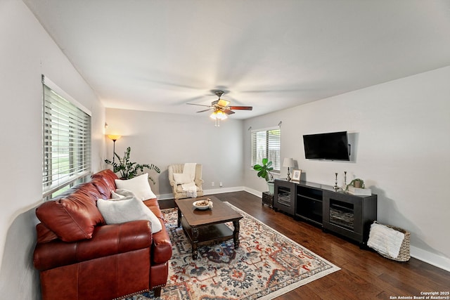 living room featuring baseboards, a ceiling fan, and wood finished floors