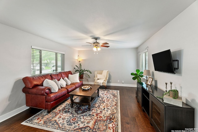 living room with baseboards, ceiling fan, a healthy amount of sunlight, and dark wood-type flooring