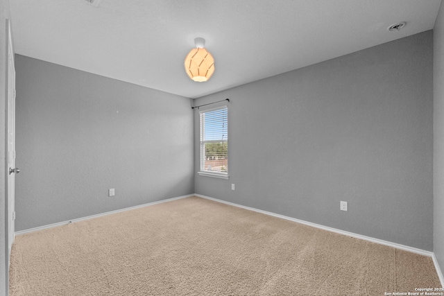 spare room featuring baseboards and carpet flooring