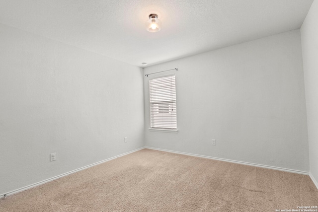 carpeted empty room with baseboards