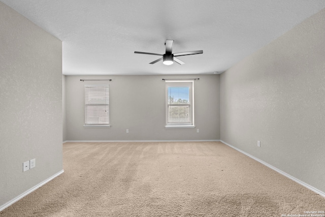 carpeted empty room with baseboards and ceiling fan