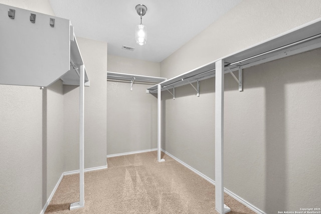 spacious closet featuring visible vents and light carpet