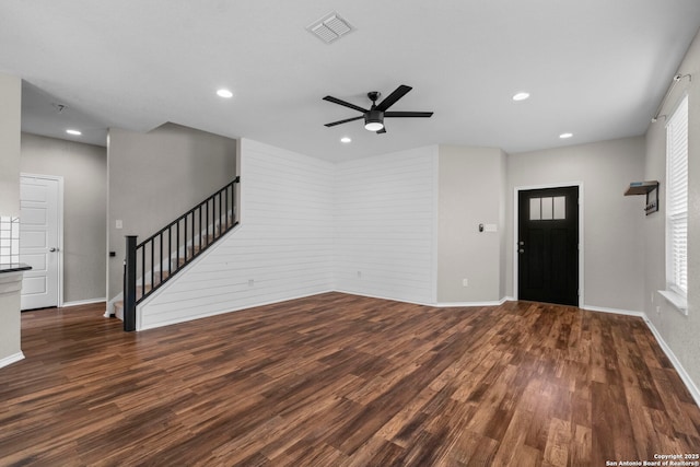 unfurnished living room featuring ceiling fan, stairs, baseboards, wood finished floors, and visible vents