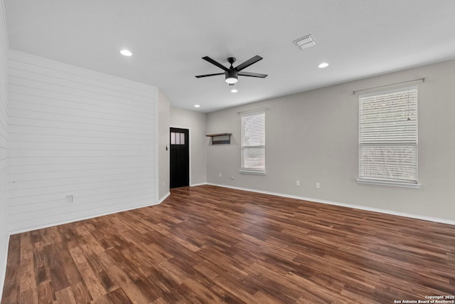unfurnished room featuring ceiling fan, visible vents, a wealth of natural light, and wood finished floors