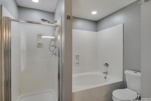 bathroom with a textured wall, a tub, toilet, and a shower stall
