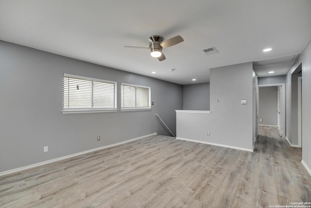 spare room with light wood-style floors, a ceiling fan, baseboards, and visible vents