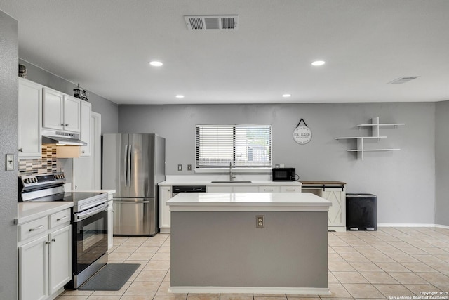 kitchen with visible vents, a sink, light tile patterned floors, under cabinet range hood, and stainless steel appliances