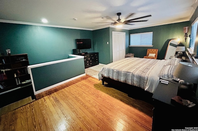 122 Hartford Ave, San Antonio, TX 78223 - bedroom with crown molding, a ceiling fan, wood finished floors, and a closet