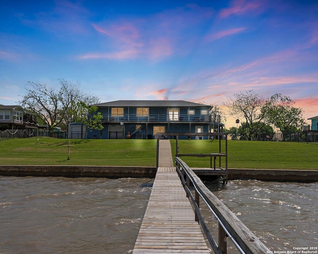 dock area with a water view and a yard