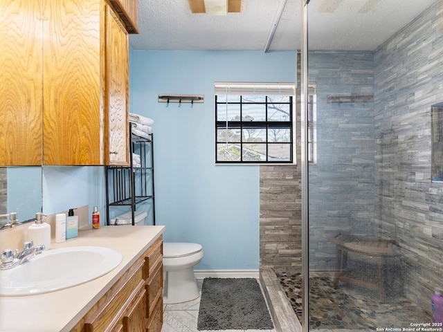 full bath featuring vanity, toilet, a textured ceiling, baseboards, and a stall shower