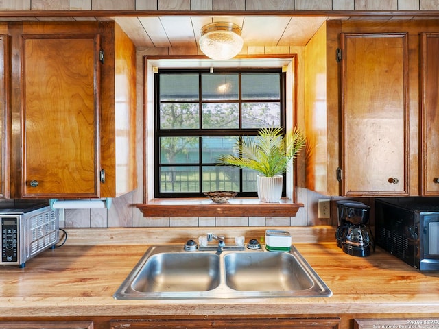 kitchen with a sink, brown cabinetry, and butcher block countertops