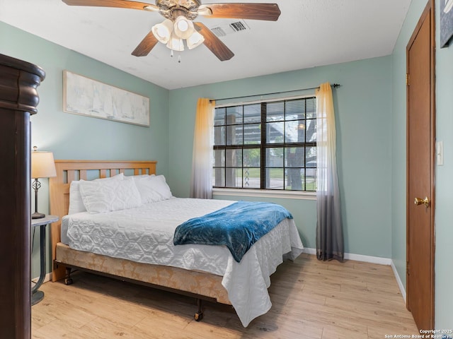 bedroom with visible vents, light wood-style flooring, ceiling fan, and baseboards