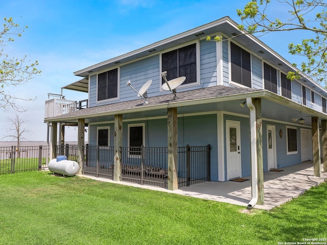 view of front of house with fence, a shingled roof, and a front lawn