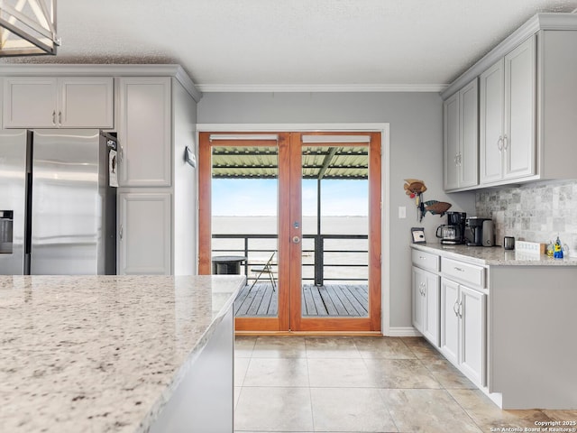kitchen with crown molding, stainless steel fridge with ice dispenser, gray cabinets, french doors, and tasteful backsplash