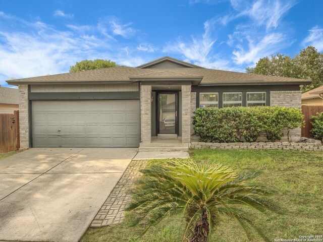 ranch-style house featuring concrete driveway, an attached garage, fence, and roof with shingles