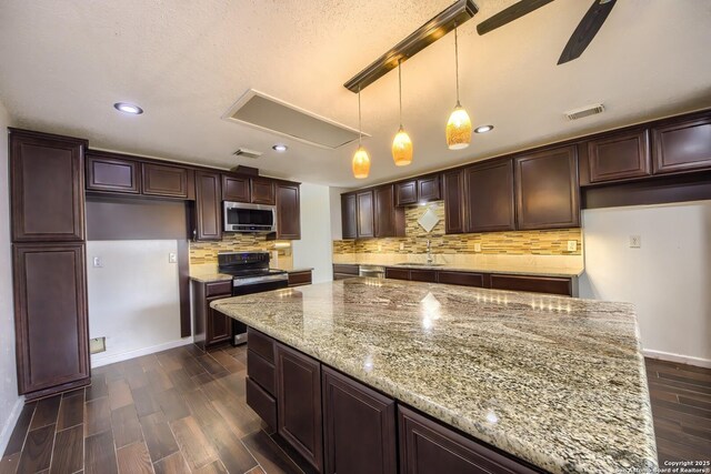 kitchen with a sink, dark wood finished floors, stainless steel appliances, tasteful backsplash, and visible vents
