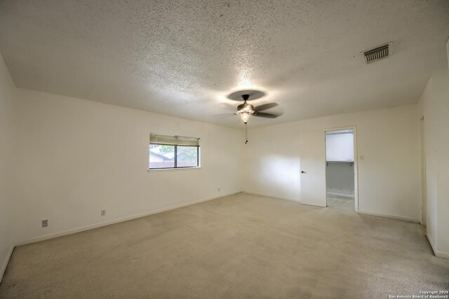 spare room featuring a ceiling fan, a textured ceiling, visible vents, and baseboards