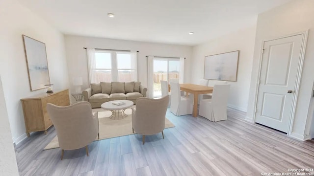 living room with light wood-type flooring, recessed lighting, and baseboards