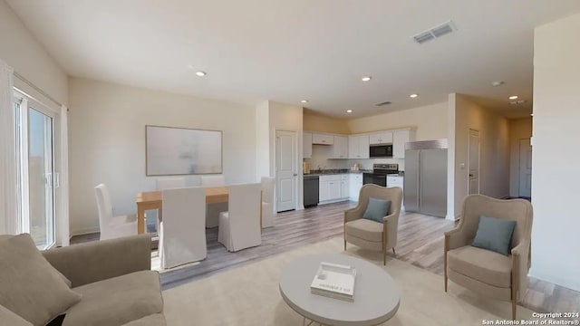 living room featuring visible vents, recessed lighting, and light wood-style flooring