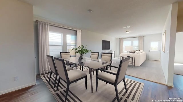 dining space featuring plenty of natural light, baseboards, wood finished floors, and visible vents