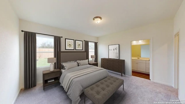 carpeted bedroom featuring ensuite bathroom and baseboards