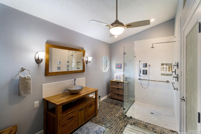 bathroom featuring a ceiling fan, walk in shower, lofted ceiling, and vanity