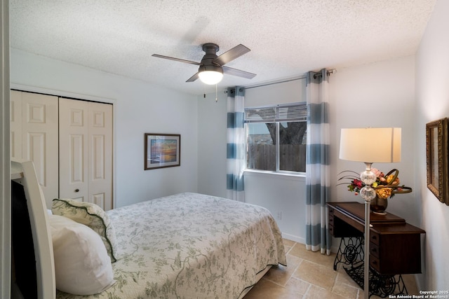 bedroom featuring stone finish floor, ceiling fan, a closet, and a textured ceiling