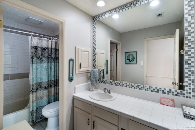 full bathroom with vanity, toilet, a textured ceiling, shower / bath combo with shower curtain, and visible vents