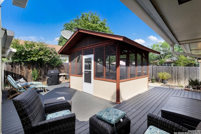 wooden terrace featuring a sunroom, a fenced backyard, outdoor lounge area, and area for grilling