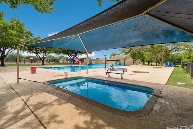 community pool featuring fence and a patio