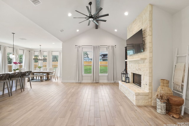 3818 Cualquiera, San Antonio, TX 78261 - living area with ceiling fan, a stone fireplace, beam ceiling, a chandelier, and light wood-style flooring