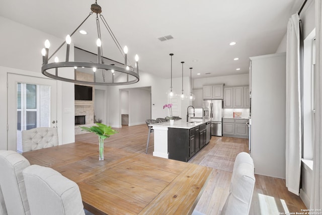 3818 Cualquiera, San Antonio, TX 78261 - dining room featuring a fireplace, light wood finished floors, recessed lighting, baseboards, and lofted ceiling