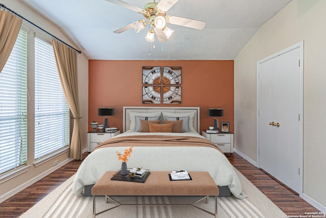 bedroom with baseboards, dark wood-style flooring, and lofted ceiling