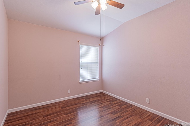 unfurnished room with dark wood-type flooring, a ceiling fan, baseboards, and vaulted ceiling
